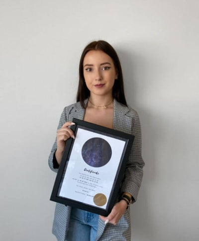 Joven sosteniendo su certificado de regalo de estrella